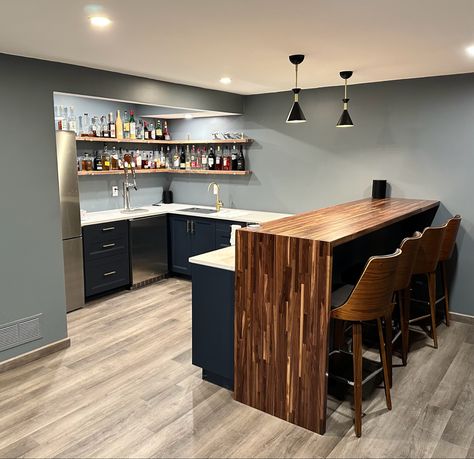 Modern basement bar using IKEA cabinets and waterfall bar top Basement Bar Plans Modern, L Shaped Bar Against Wall, U Shaped Basement Bar, Mini Bar Ideas For Home, L Shape Basement Bar, Basement Bar U Shape, Bar Wall Design, Basement Wet Bar Table & Stools, Modern Basement Bar