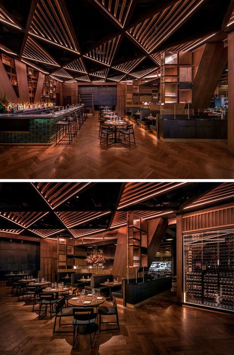 This modern restaurant's distinctive and massive structural joists divide the bar area from the main dining room. These angled columns& inspired the bar’s geometrical millwork and its triangular patterned wood trellis ceiling. #RestaurantDesign #ModernRestaurant #RestaurantInterior Bar Ceiling Lights, Spain Restaurant Interior, Celing Roof Design For Restaurant, Triangular Ceiling Design, Back Bar Design Restaurant Modern, Restaurant Ceiling Design Modern, Bar Ceiling Design, Cafe Ceiling Design, Trellis Ceiling