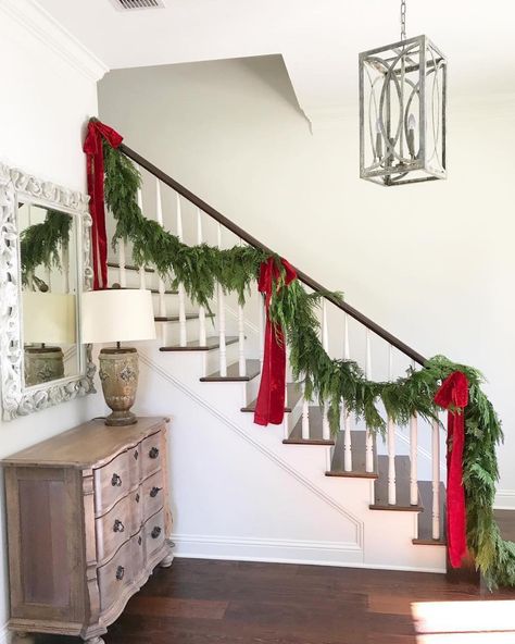 Fresh cedar garland on staircase with red velvet ribbon Christmas Tree Ribbon Garland, Christmas Banister, Christmas Stairs Decorations, Christmas Stairs, Christmas Staircase, Front Porch Christmas Decor Ideas, Porch Christmas Decor Ideas, Porch Christmas Decor, Front Porch Christmas