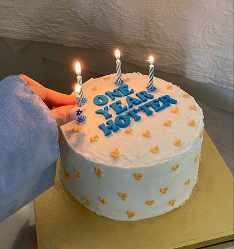 putting blue candles on a white birthday cake with yellow hearts and blue font saying „one year hotter“ Aesthetic Birthday Cake Pictures, Birthday Cake With Quotes, Birthday Cake For Myself, Funny 26 Birthday Cake, Birthday Cake Text Ideas, Cakes Aesthetic Birthday, Bff Birthday Cake, Birthday Cake Best Friend, Cake Candles Aesthetic