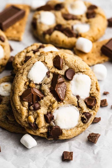 Our delicious S'mores Cookies start with a thick and chewy graham cracker cookie base, loaded with chocolate and marshmallows. Chocolate Chip Cookie S’mores Recipe, Oreo Smores Cookies, Graham Cracker Smores Cookies, Homemade Smores Cookies, S'mores Chocolate Chip Cookie, S’mores Chocolate Chip Cookie, S'more Cookies Recipe, Crumbl Cookie Copycat Smores, Gram Cracker Cookies