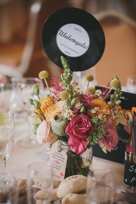 Gorgeous floral table centre piece using vinyl records as table names.  From 'An Original 1950s Vintage Gold Wedding Dress For A Fun And Colourful Italian Inspired Wedding'.  http://www.mckinley-rodgers.com/ 1950s Wedding Decor, Gold Wedding Ceremony, Record Wedding, Music Festival Wedding, 80s Wedding, Italian Inspired Wedding, Dress Fur, 50s Wedding, 1950s Wedding Dress