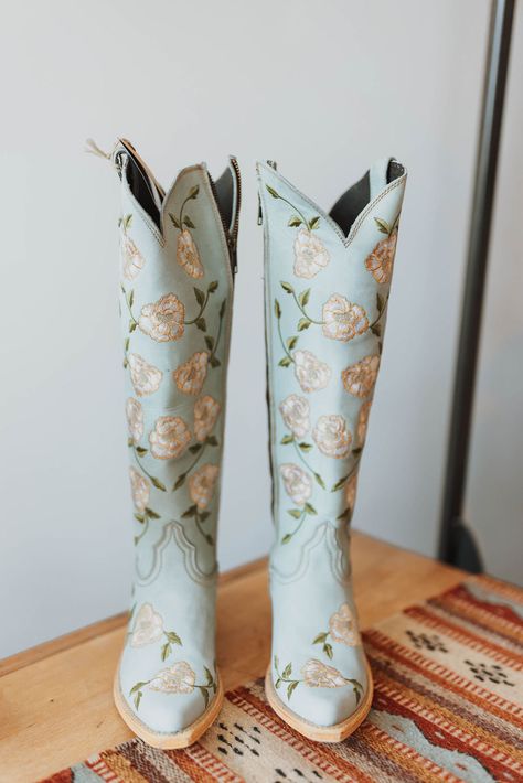 The wow factor is real on every inch of these floral embroidered boots by Liberty Black! We are loving that leather mixed with floral embroidery in a tall cowboy boot silhouette! They'll pair beautifully with jeans, dresses, or leggings year around. This look is sweet and chic, you'll be a country cutie with a side of southern charm. By Libery Black Fit || True to size Shaft Height - 15" Heel Height - 2" Toe - Snip Standard Width Measurements are based on size 8 - measurements may vary slightly Something Blue Cowboy Boots, Floral Cowgirl Boots, Blue Cowgirl Boots, Wedding Cowboy Boots, Cute Cowgirl Boots, Custom Cowboy Boots, Boot Silhouette, Country Shoes, Glamour Vintage