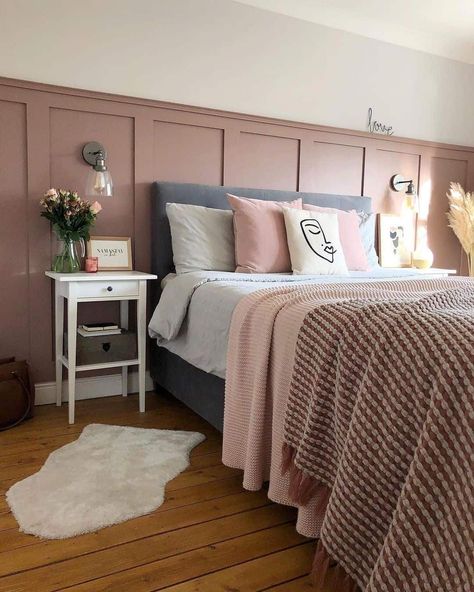 A modern grown-up pink bedroom is styled with a gray bed dressed in modern pink bedding and layered with white, pink, and gray accent pillows. Light walls brighten the space and a muted pink batten wainscoting accent panel provides a pleasing definition. Mounted wall sconces flank either side of the bed above white side tables accessorized with modern accents...   Image: athomewiththeraines Pink Wainscoting, Accent Wall Girls Bedroom, Light Pink Bedrooms, White Metal Bed, House Renovation Design, Pink Accent Walls, Light Walls, Pink Bedroom Walls, Gray Bed