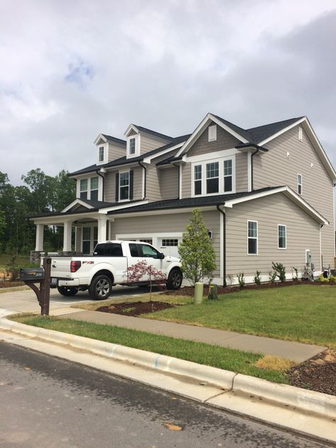 Charcoal grey (almost black) gutters. Beige House With Black Roof, Taupe And Black Home Exterior, White House Brown Gutters, Dark Gutters On Light House, Dark Gutters On Brick House, Black Gutters Tan House, Black Gutters Gray House, Black Gutters, House Gutters