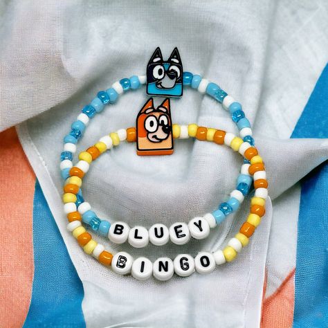 Custom Bluey and Bingo Charm Bracelet  ✨ Please be sure to choose your style of choice and your bracelet size before checking out ✨ ☆ 𝙲𝙰𝚁𝙴 ☆ To maintain the quality of your SimplyjustKnotted piece,  -avoid direct contact with perfumes, lotions, and other chemicals  -remove when bathing, showering, swimming and sleeping  ☆𝚀𝚄𝙴𝚂𝚃𝙸𝙾𝙽𝚂☆ If you have any questions, please feel free to send me a message. I want you to love your pieces as much as I love making them❤️ Have fun picking out your favorite piece! ☆𝚂𝙸𝚉𝙴𝚂☆ Standard (non-specified) size will be 6.5 inches  6"kids/tween 6.5" standard woman 7" 7.5" me 8" standard men ☆Children Sizes☆ 4-5 Yrs- 5.75 inches 6-7 Yrs- 6 inches 8-9 Yrs- 6.25 inches 10-11 Yrs-6.5 inches 12-14 Yrs 6.75 inches Bluey Mom, Bingo Funny, Custom Charm Bracelet, Bluey And Bingo, Custom Bracelet, Choose Your Style, Custom Charms, Man Child, Bracelets Handmade Beaded