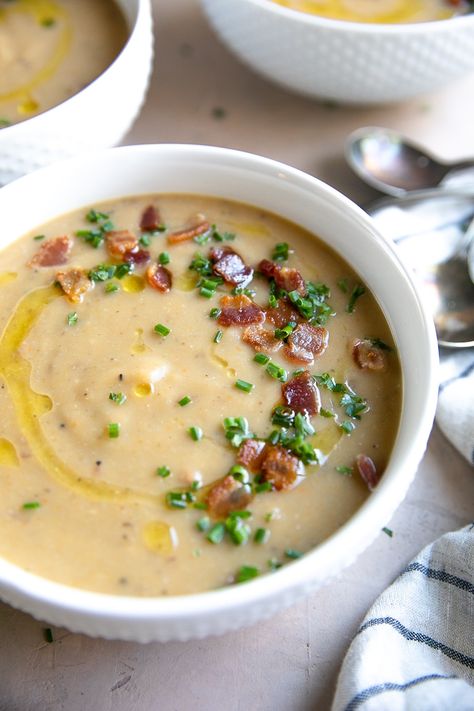 White bowls filled with dairy-free leek and potato soup topped with bacon bits and chives Cauliflower Ideas, Brewery Food, Cookies Banane, Leek And Potato Soup, Leek And Potato, Creamy Potatoes, Spring Meals, Winter Soup Recipe, Potato Leek