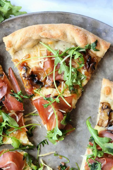 Greens top off salty prosciutto meat and sweet caramelized shallots and mushrooms in this Arugula Prosciutto Pizza. Heat a pizza stone or baking pan so you can really get a crispier crust! #arugulaprosciuttopizza #arugulaandprosciuttopizza #pizza #arugulapizza #glutenfree #glutenfreepizza #recipe #dinner #gourmet | Recipe at Delightful Mom Food Prosciutto Balsamic Pizza, Mushroom Prosciutto Pizza, Homemade Pizza Prosciutto, Arugula And Prosciutto Pizza, Fruit Flatbread, Fun Date Night Dinner Recipes, Prosciutto Flatbread Pizza, Gourmet Pizza Toppings, Healthy Flatbread Pizza