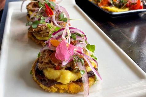 Fundamentally, tostones are just pressed, deep-fried green plantains — similar to a patacon, just made in smaller dimensions. It’s a common side starch, and not particularly flavorful. However, when chefs use tostones as a base or an edible vessel, like potato skins, snack magic happens. You might see them topped with shrimp and avocado, with pulled pork and pineapple, with vaca frita and beyond. At Coral Gables hot spot Seek & Find, tostones are on the appetizer menu topped with braised pork, m Tostone Appetizers, Tostones Appetizer, Shrimp Tostones, Pork And Pineapple, Stone Crab Claws, Green Plantains, Restaurants In Miami, Shrimp And Avocado, Stone Crab