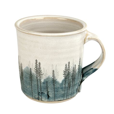 Artist: Red Bison Studio Approximately 4" tall x 4" wide This mug features a hazy blue mountain landscape behind several bunches of lodge pole pines. A bright large sun stands alone in the sky, and pearlescent glaze covers the inside and outside of the mug. Inspired by driving up a winding road into the Big Horn Mountains in Northern Wyoming. I hope this transports you to your favorite forested mountain spot. Food, dishwasher and oven safe, but it is actual gold on the mug so it is not microwava Mountain Mug Pottery, Mountain Mugs, Ceramic Mountain, Xmas Mugs, Elk Silhouette, Mugs Diy, Mountain Mug, Line Artist, Mountain Tree