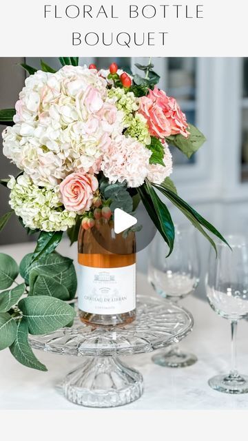 Janine Graff on Instagram: "Wine Bottle Floral Bouquet💐 What better way to receive a bottle of wine or beverage bottle than one that is crowned with a beautiful bouquet of flowers on top!

This is such an easy and elegant way to elevate your next gift to that special Mom, Bride to Be, Hostess or Birthday Gal! 

💐I forgot to show you that I soaked the florist foam aqua block in water before placing on top of my bottle. I used FRESH florals but you could use faux florals too. 

After presenting your wine bottle arrangement, the recipient of your gift will be able to easily slide the bouquet up and off of the bottle neck and can then place it in a bowl or vase with water to enjoy for at least a week. 

This arrangement can be created using any type of beverage bottle for a unique and memora Janine Graff, Wine Bottle Flowers, Wedding Centerpeices, Boho Valentine, Winter Wedding Bouquet, Beverage Bottle, Holiday Deco, A Bottle Of Wine, Stacked Pumpkins