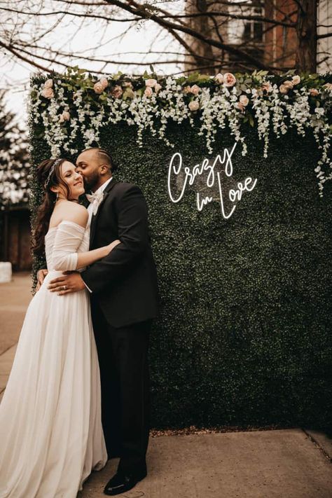 Greenery backdrop with flowers and a neon sign! Photo: JC Photography Floral Backdrops For Weddings, Neon Sign Wedding Backdrop, Infinity Mirrors, Wedding Photo Walls, Diy Photo Backdrop, Wedding Hoop, Fake Wedding, Party Backdrops, Photo Backdrop Wedding