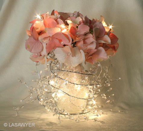 Pretty reception centerpiece - made with silk flowers, an ice-drop garland, white LED lights, a glass vase, and shredded cellophane filler. Deco Rose, Wedding Reception Centerpieces, Reception Centerpieces, Light Garland, Deco Floral, Wedding Centerpiece, Centre Pieces, Wedding Lights, Wedding Favor