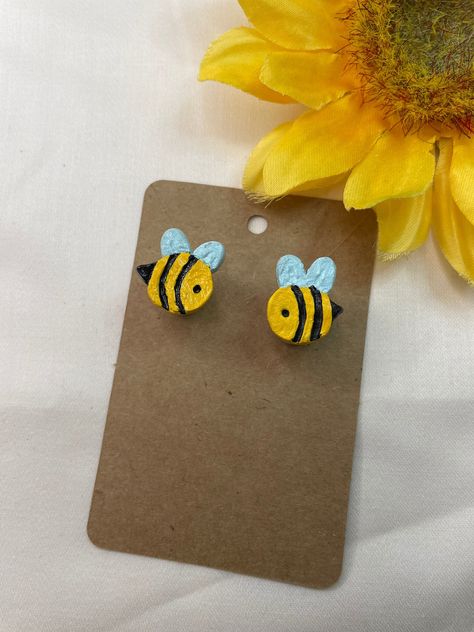 Bees might seem seasonal, but those little guys are nonstop and deserve the respect from it! These small stud earrings call on direct inspiration from our hardworking bumblebee friends, who are always working it. Light blue wing, black and yellow body, and confidence to last a lifetime! These little guys are created using jewelry quality polymer clay, acrylic paint, a shiny protective coating, and sterling silver pushback studs! Bee Earrings Clay, Polymer Clay Bee, Clay Earrings Studs, Polymer Charms, Jewellery Diy, Spelling Bee, Unique Jewelry Gifts, Blue Wings, Bee Earrings