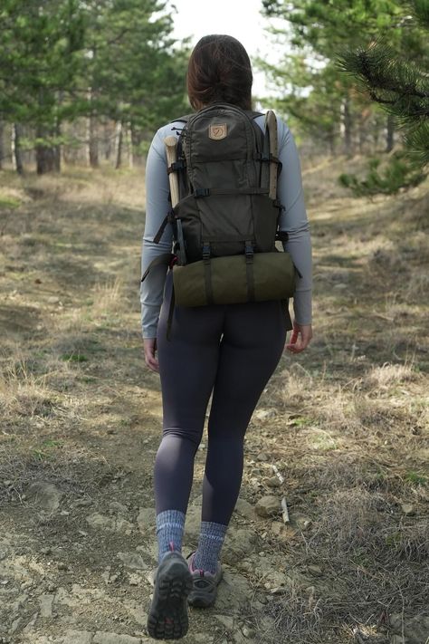 Woman hiking through a forest, viewed from behind, wearing a backpack and athletic clothing. On The Road Outfit, Feminine Camping Outfit, Off Roading Outfit, Cold Hiking Outfit Women, Walking Outfit Outdoor, Stylish Hiking Outfit, Hiking Picture Ideas, Hiking Outfits Summer, Trail Outfits