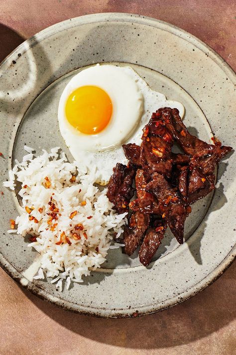 Tapsilog, a popular Filipino meal, is a portmanteau of the dish’s three components: tapa (beef), sinangag (garlic fried rice), and itlog (fried egg). It’s one of many variations of silog (garlic fried rice plus fried egg). While this recipe is fairly straightforward, we'll also tell you a few ways to ensure a great result. Though silog is traditionally served for breakfast, it makes a savory, satisfying meal any time of day. Tapsilog Recipe, Silog Meals Ideas, Silog Meals, Restaurant Mood Board, Filipino Restaurant, Garlic Fried Rice, Cooking Jasmine Rice, Meals Ideas, Food Homemade