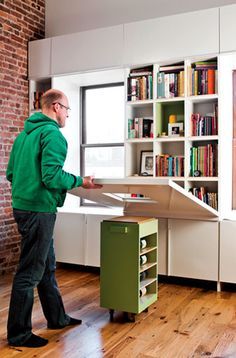 2010, Dwell showcased a wall hiding a bookshelf that folded down to create a table set atop a rolling island Fold Down Table, Mini Loft, Space Saving Solutions, Tiny Living, Book Shelf, Small Space Living, Space Savers, Small Living, Apartment Living