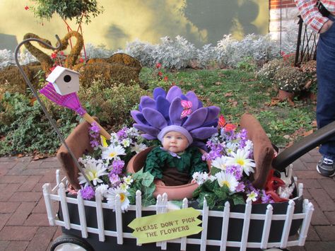 Flower garden made from wagon costume Fairy Wagon Halloween, Halloween Costumes With Wonderfold Wagon, Family Fruit Costumes, Decorate Wagon For Halloween, Wagon Costumes For Babies, Family Halloween Costumes With Wagon, Wagon Decorations For Halloween, Baby Wagon Halloween Costume, Wonderfold Wagon Halloween Costumes