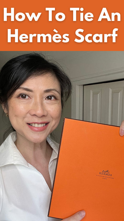 asian woman over 50 holding orange Hermes scarf box. How To Tie An Hermes Scarf, Outfits With Hermes Scarf, Diy Silk Scarf How To Make, Ways To Wear An Hermes Scarf, European Scarf Outfit, How To Tie Hermes Silk Scarf, Hermes Scarf 90 Outfit, How To Tie A Square Knot Scarf, How To Wear A Small Silk Scarf