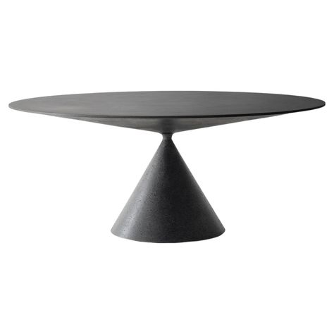 A table capable of expressing the perfect synthesis between sculpture and proportions, design harmony and high-level craftsmanship. Clay is a table with pure aesthetics, capable of communicating personality wherever you decide to place it: in a dining room, living space or more. The top and the base are grafted onto each other with a daring game of balance thanks to a section reduced to a minimum. The special lava stone cladding amazes and fascinates with its dark shades, rich in porosity that m Round Concrete Dining Table, Concrete Clay, Italian Table, Grey Paint, Stone Cladding, Table Ronde, White Concrete, Oval Table, Dark Shades