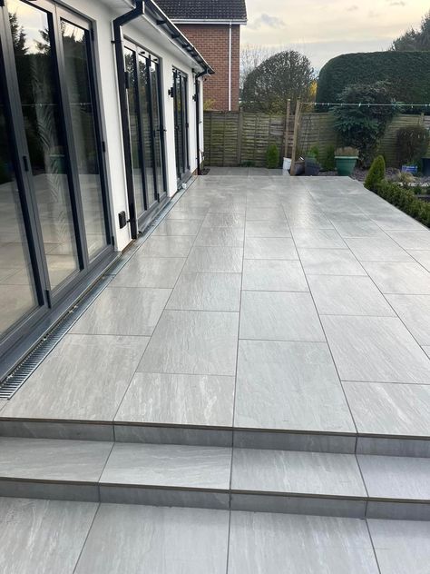 A modern patio while using a traditional look paver. This porcelain paver has realistic characteristics to natural stone. This patio was completed by Dunnington Landscapes Ltd using Aged Kandla Grey porcelain, this paving is available in 600x600mm and 600x900mm. 📞Call our team on 01977 782240 💻Visit the product on our website https://rflandscapeproducts.co.uk/product/aged-kandla-grey-2cm-porcelain-paving/ Details ✔️ Product : Aged Kandla Grey Format - 600x900mm Credit - Dunnington Lands... Porcelain Garden Paving, Kandala Grey Sandstone Patio, Grey Indian Sandstone Patio, Kandla Grey Porcelain Patio, Dark Grey Patio Paving, Modern Patio, Patio Garden, Natural Stones, Porcelain