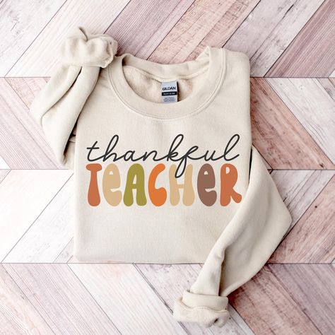 Thankful Teacher Sweatshirt, Thanksgiving Teacher Shirts for Men & Women, Thanksgiving Gift for Teacher, Autumn Teacher Tees, Fall Vibes Tee ---------- Ordering Your Custom Design T-shirt: Step by Step ---------- 1. Select your preferred t-shirt color. 2. Specify your desired size. 3. Pick the color for both your design and text. 4. Ensure that each step of your order is accurately completed. M A T E R I A L S → Our solid color options such as White and Black consist of 100% Cotton. → The Heathered Colors are a blend of cotton and polyester, ensuring a luxuriously soft feel. → Crafted as Short Sleeve Crew-Neck Unisex T-Shirts. → Composed of soft, high-quality Sueded Jersey fabric. → Taped shoulder-to-shoulder for enhanced durability. → Side Seamed for a refined finish. → Boasts a Retail fi Thanksgiving Teacher Shirts, Fall Teacher Shirts, Teachers Thanksgiving, Teacher Sweatshirt, Teacher Tees, Thanksgiving Gift, Gift For Teacher, Mens Long Sleeve Tee, Fall Sweatshirt