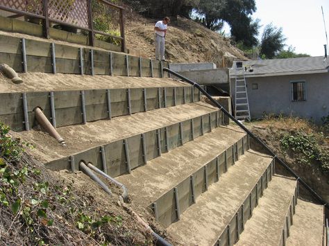 Hillside Repair Pipe and Board Sloped Hill Landscape Ideas, Steep Hill Landscaping, Steep Hillside Landscaping, Hillside Deck, Hillside Landscape, Wood Retaining Wall, Hill Landscaping, Terraced Landscaping, Landscaping On A Hill