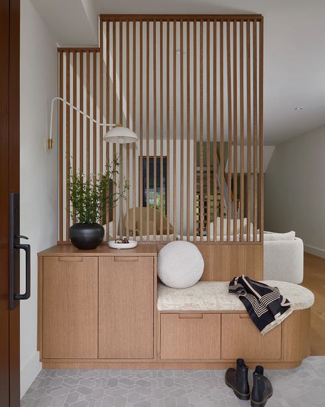 Project Sherwood Park by Four Blocks South front entry bench and slat screen | Portfolio Front Entry Bench, Entryway Divider, Slatted Walls, Half Wall Room Divider, Japandi House, Medical Office Decor, Modern Room Divider, Lobby Interior Design, House Staircase