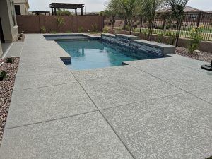 Our team loved working on a recent pool deck project using grey acrylic lace to create a contemporary look. In recent years grey pool decks have become increasingly popular and are a trending design style. White Concrete Pool Deck, Poured Concrete Pool Deck, Salt Finish Concrete Pool Deck, Pool Deck Paint Ideas Concrete, Gray Pool Deck, Cool Decking Around Pool, Brushed Concrete Pool Deck, Stamped Concrete Around Pool, Trending Home Design