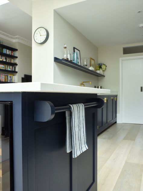 This painted wooden towel rail works very well at the side of the kitchen island, hidden underneath a small overhang on the quartz worktop. The towel rail is painted in the kitchen cabinet colour by Little Greene. Kitchen Towel Rail Ideas, Kitchen Storage Above Radiator, Brass Kitchen Rail With Hooks, Dark Grey Kitchen Brass Handles, Brass Rail Kitchen Shelf, Kitchen Towel Rail, Wooden Towel Rail, Dark Blue Kitchens, Hand Towels Kitchen