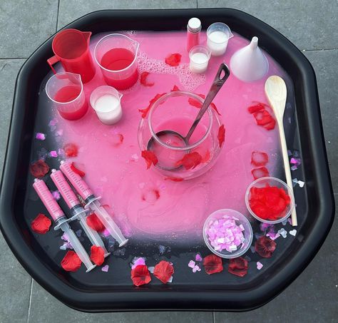 Love Potions 💕 - Valentine’s Day inspired - Water play - Colour mixing - Creative and imaginative play ❤️ Potion base is created using water mixed with pink paint and glitter ❤️ Red and white paint mixed with water in the beakers ❤️ Love heart confetti and fake rose petals in containers and used as decorations #tufftray #tufftrayideas #tufftrayactivities #tufftrayinspiration #tufftrayplay #tufftrayfun #tuffspot #tuffspotideas #playtray #playtrayideas #sensoryplay #waterplay #eyfs #ea... Potion Water Play, Potion Tuff Tray Ideas, Pink Tuff Tray Ideas, Early Years Creative Activities, February Sensory Table Ideas, Fairy Tuff Tray, Flowers Tuff Tray, Pink Activities For Preschool, Valentines Tuff Tray Ideas