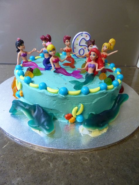 Ariel, Little Mermaid birthday cake. As requested by the birthday girl, Ariel and her sisters at the top, fish in the middle and sharks at the bottom. So simple yet so effective. Simple Mermaid Birthday Cake, Simple Mermaid Birthday Cake Diy, Arial Birthday Cake, One Tier Mermaid Birthday Cake, Ariel Birthday Cake Simple, Ariel Cake With Doll, Purrmaid Cake, Little Mermaid Birthday Cake, Ariel Cake