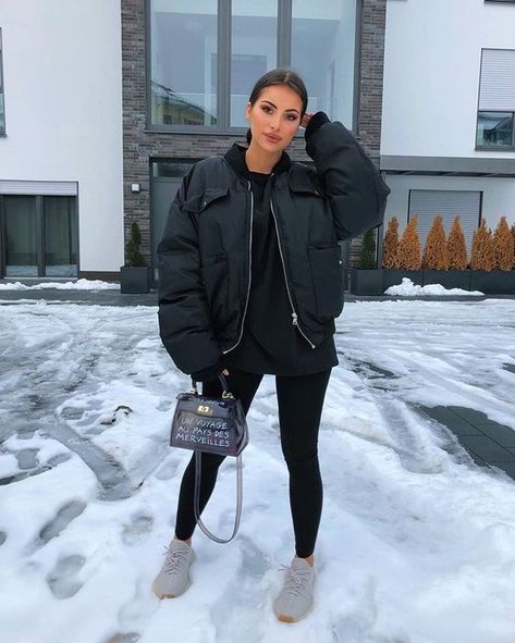 a sporty winter outfit with a black hoodie, leggings, a padded bomber jacket, grey trainers and a printed bag Tight Ponytail, Vinter Mode Outfits, Basic Ootd, Yeezy Outfit, Pastel Outfit, Bags Luxury, Chill Outfits, Cute Winter Outfits, All Black Outfit