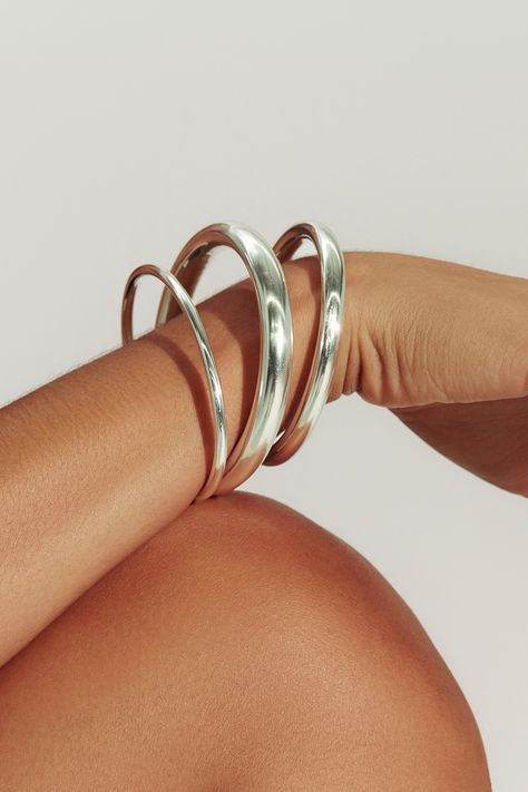 A modern essential, our sterling silver open cuff has the perfect weight and thickness for everyday wear. Layer with our varying widths and finishes for an architectural stack. Jewelry Collection Handcrafted in Brazil Sterling Silver over Brass Thickness: 5.8mm Inner Diameter: 2.5" Opening: 1.25" Weight: 0.36 oz Waterproof Hypoallergenic Funky Silver Jewelry, Modern Everyday Jewelry, Stacked Jewelry Silver, Sculptural Bracelet, Stack Jewelry, Silver Bracelet Stack, Big Bracelets, Open Cuff Bracelet, Naked Wardrobe