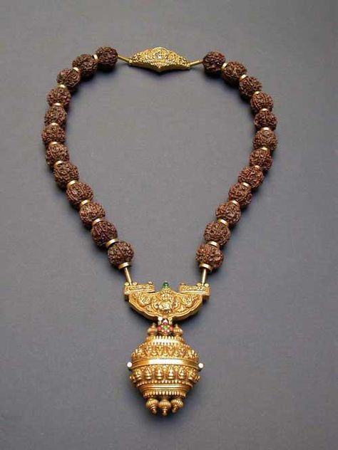 According to the seller this is a Govrishankaram - a necklace of rudraksha beads with a gold repoussé pendant and an amulet box suspended below.The Rudraksha beads are interspersed with gold rings and a repoussé gold worked pendant and clasp. Worn by a Shaivite priest only on a special ceremony. Rudraksha Necklace, Rudraksha Jewelry, Rudraksha Beads, Antique Gold Jewelry, Bridal Gold Jewellery Designs, India Jewelry, Ancient Jewelry, Temple Jewellery, Tamil Nadu