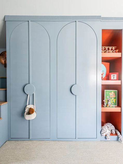 Built-in storage clutter stays out of sight behind these arched closet doors Built In Wardrobe Kids Room, Playroom Cupboards, Playful Interior Design, Arched Cabinet Doors, Kids Room Closet, Closet Playroom, Kids Nursery Ideas, Movie Seats, Blue Wardrobe