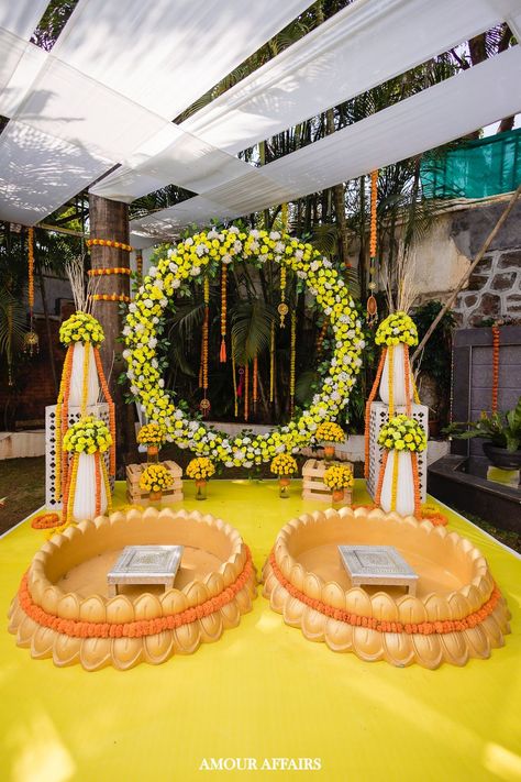 Round marigold backdrop, urli seating Haldi Decoration For Couple, Haldi Backdrop For Groom, Couple Haldi Decoration Ideas, Haldi Urli Decor, Simple Elegant Engagement Decor, Haldi Ceremony Decorations For Groom, Haldi Decoration Ideas For Groom, Urli For Haldi, Haldi Backdrop Stage Decorations