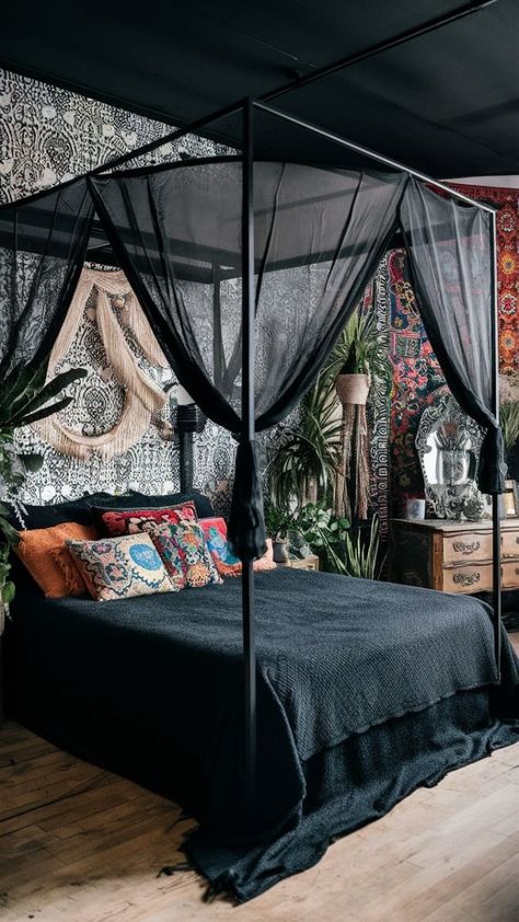 A captivating photo of a black boho-style bedroom, featuring a canopy bed with a sheer black canopy, adorned with a variety of colorful and eclectic cushions. The walls are adorned with a mix of intricate black and white wallpaper and colorful bohemian tapestries. The room also features a vintage-style wooden dresser, a decorative mirror, and an array of plants adding life and freshness to the space., photo Black Metal Canopy Bed With Curtains, Canopy Bed Couple, Goth Canopy Bed Ideas, Diy Canopy Bed For Adults Romantic Bedroom Ideas, Eclectic Cushions, Large Boho Bedroom, Black Boho Bedroom, Dark Romantic Bedroom, Bedroom Design Boho