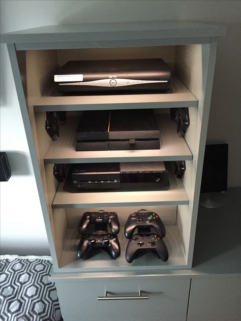 Hidden Console Storage, Hide Games Console, Gaming Cabinet Ideas, Console Gaming Setup Living Room, Hide Gaming Systems, Diy Game Console Storage, Games Console Storage Ideas, Game Console Organization Living Room, Video Game Storage Ideas Living Room