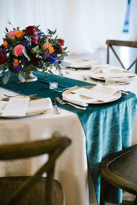 A beautiful upgraded cream linen paired with a dark teal velvet runner. Champagne chargers. Antique brass vases are holding the beautiful jewel-toned flowers and greenery. Linens are from White Table and Florals are Lisa Foster. Dark Teal Table Runner Wedding, Teal Table Runner Wedding, Teal Table Setting Wedding, Dark Teal Wedding Table Setting, Jewel Tone Round Table Wedding, Dark Teal Table Runner, Jewel Tone Table Decor, Dark Teal Table Setting, Jewel Tone Wedding Table Settings