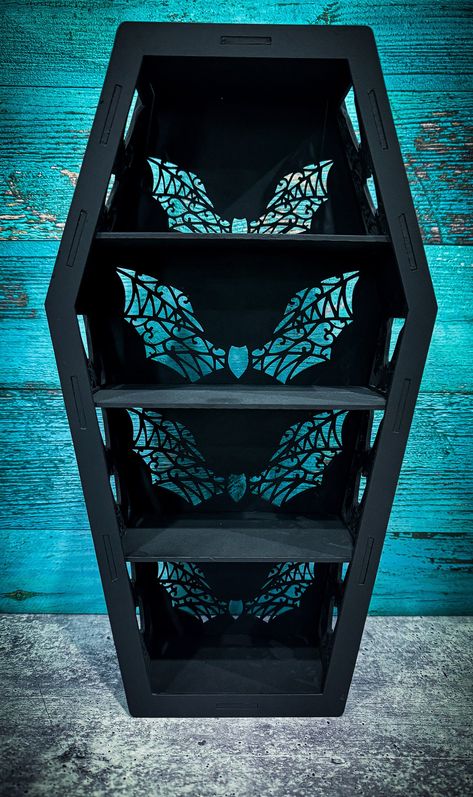 This Lacey bat Coffin Shelf is the perfect addition to any Gothic-themed space. Handmade with high-quality wood and Mdf Wood, this shelf is both sturdy and stylish. The black color and decorative style make it a unique piece of home décor, perfect for displaying your favorite items. perfect for displaying crystals or trinkets  15x4x8 inch shelf Comes in different styles Gothic Office Ideas, Goth Shelf Ideas, Witchy Shelves, Coffin Shelf Diy Plans, Goth Shelves, Coffin Shape Shelf, Coffin Display Shelf, Coffin Wall Shelf, Elder Goth