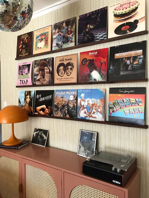 Record albums hung on picture ledges above sideboard with record player and lamp. Records On Wall Aesthetic, Record Player Wall, Vinyl Record Wall Display, Record Wall Display, Clean Vinyl Records, Vinyl Record Shelf, Picture Ledges, Record Wall Art, Vinyl Records Wall