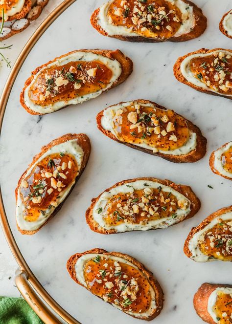 These figgy goat cheese crostini belong at your next get-together with friends! This appetizer has crispy crostini, goat cheese, honey, walnuts, thyme, and fig jam. Layer them up and bake them in the oven for a super easy, crowd-pleasing finger food. I love making this quick and easy appetizer for dinner parties and holidays like Thanksgiving or Christmas. It's even make-ahead! And in the post, you can find all kinds of ideas for switching up this recipe with different flavors and ingredients. Hot Honey Crostini, Individual Appetizers For Party, Crostini Goat Cheese, Crispy Crostini, Appetizer For Dinner, Honey Appetizers, Goat Cheese Honey, Honey Walnuts, Individual Appetizers