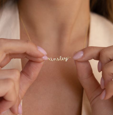 "D A I N T Y ∙ N A M E ∙ N E C K L A C E Discover our Dainty Personalized Name Necklace, a truly one-of-a-kind piece. It's the perfect gift, whether it's for yourself or your special someone! * Material: High Quality Solid 925 Sterling Silver  * Dimensions: Depending on your font choice, height sizes range from 3mm to 4mm lowercase. * Finish: Sterling Silver ∙ 18K Gold ∙ Rose Gold  ♡ Model showcases a fashionable layering look featuring:  * Dainty Mirror Chain: https://etsy.me/3RnmrAr * Pave Linked Pendant Necklace: https://etsy.me/47yBwET * Birthstone Hoop Earrings: https://etsy.me/48ivLf6 * All our jewelry is custom made by hand with Love and Care in our workshop ♡ H O W ∙ T O ∙ O R D E R  * Simply use the 'PERSONALIZATION BOX' to let us know the NAME and the FONT NUMBER that you would l Initial Tag Necklace, Romantic Christmas Gifts, Handwriting Bracelet, Fingerprint Necklace, Sideways Initial Necklace, Dainty Initial Necklace, Diamond Huggies, Cursive Font, Name Jewelry