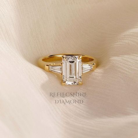 Free Shipping Main Stone: 2.50 Carat Side Stones: 0.25 Carats Total carat weight: 2.75 Carats Gold metal: 14k Yellow Gold Diamond Shape: Emerald cut Clarity: VVS2  Color: E Comments: Lab Grown Cut: Excellent All products comes with International Gemologist Certificates. Please feel free to contact me for any questions or details , gold upgrades, diamond upgrades etc' 30-Day Returns 100% Full Refund We are fully behind every diamond and piece of jewelry that we sell. It is vital for us that you a Emerald Cut Tapered Baguettes, Classic Winston Emerald-cut Engagement Ring With Tapered Baguette Side Stones, Emerald Baguette Engagement Ring, Three Stone Gold Engagement Ring, Emerald Cut Three Stone Engagement Ring, Three Stone Emerald Cut Engagement Ring, Emerald Cut With Baguettes, Gold Engagement Ring Emerald Cut, Rectangle Engagement Rings