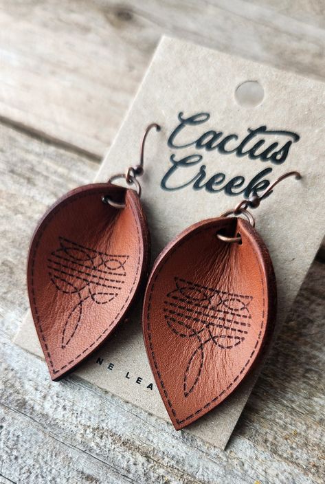 These earrings are made from genuine leather, machine engraved, lightly oiled, then hand burnished to a bright shine. Finished with antique gold findings. Diy En Cuir, Handmade Leather Jewelry, Leather Tooling Patterns, Laser Engraved Leather, Leather Jewelry Diy, Diy Jewelry Display, Cowgirl Jewelry, Leather Workshop, Western Leather