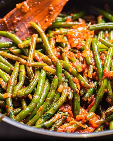 Fresh green beans are gently stewed in a tomato sauce that is full of garlic and onion flavor. Topping with fresh herbs, like basil and parsley, a drizzle of extra virgin olive oil, and plenty of grated Pecorino or parmesan brings this dish to the next level! #greenbeans #stringbeans #italiansides #summerrecipes #italianrecipes Green Beans In Tomato Sauce Recipe, Green Beans With Tomato Sauce, Green Beans With Sauce, Green Beans With Tomatoes And Onion, Italian Green Beans Recipe, Green Beans In Tomato Sauce, Bean Ideas, Beans In Tomato Sauce, Guacamole Dip Recipes