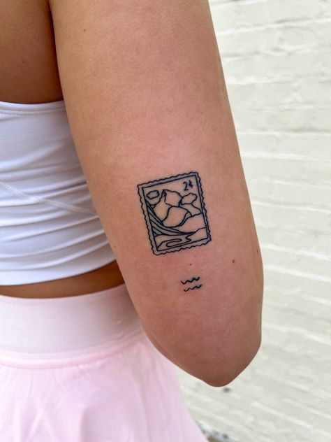 she has a tattoo of a stamp with mountains in the tattoo. under that tattoo is a small aquarius tattoo. black ink tattoos Switzerland Tattoo Ideas, Stamp Tattoo Mountains, Mountain Stamp Tattoo, Small Stamp Tattoo, Austria Tattoo, Australia Tattoo Ideas, Aus Tattoo, Switzerland Tattoo, Star Sign Tattoo