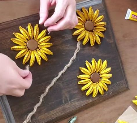 Bottlecap Flowers Diy, Diy Sunflower Wall Art, Bottle Cap Crafts Flowers, Sunflower Bottle Cap Art Diy, Beer Bottle Caps Crafts, Bottle Cap Sunflower Art, Sunflower Gifts Ideas Diy, How To Make Bottle Cap Art, Bottle Cap Flower Art