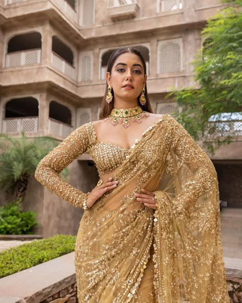 Liquid gold vibes 🌟 ...... MARISTELA - Metallic gold hand embroidered saree with a full sleeve blouse along tassel droplets at waist and gorgeous sequins edging. Cosmos: A Cocktail Affair Discover the collection: Online at Roujeofficial.com via link in bio Calcutta | Hyderabad Jewelry:@gkchudiwalas [ Roujeofficial, rouje, Cosmos, feathered cape, tassels, crystals, sequins, hand embroidery, cocktail saree, party outfits, after party outfit, bridesmaid outfit, Sangeet, wedding day, re... Golden Sangeet Outfit, Cocktail Party Outfit Bride, Gold Blouses For Sarees, Golden Saree Bridal Look, Full Sleeve Blouse Designs Saree Indian Weddings, Lengha Blouse Designs Full Sleeves, Full Sleeve Saree Blouse Design, Full Sleeves Blouse Designs Saree, Reception Outfit Bridesmaid